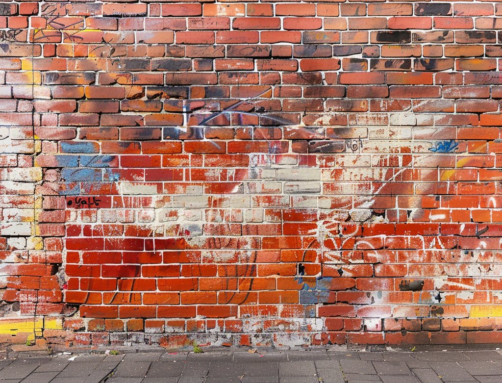 Heritage brick wall with graffiti before laser cleaning